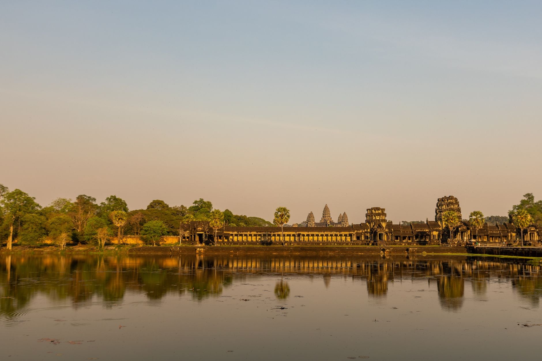 Il complesso templare di Angkor Wat si riflette nelle calme acque del fossato all'alba, Siem Reap, Cambogia