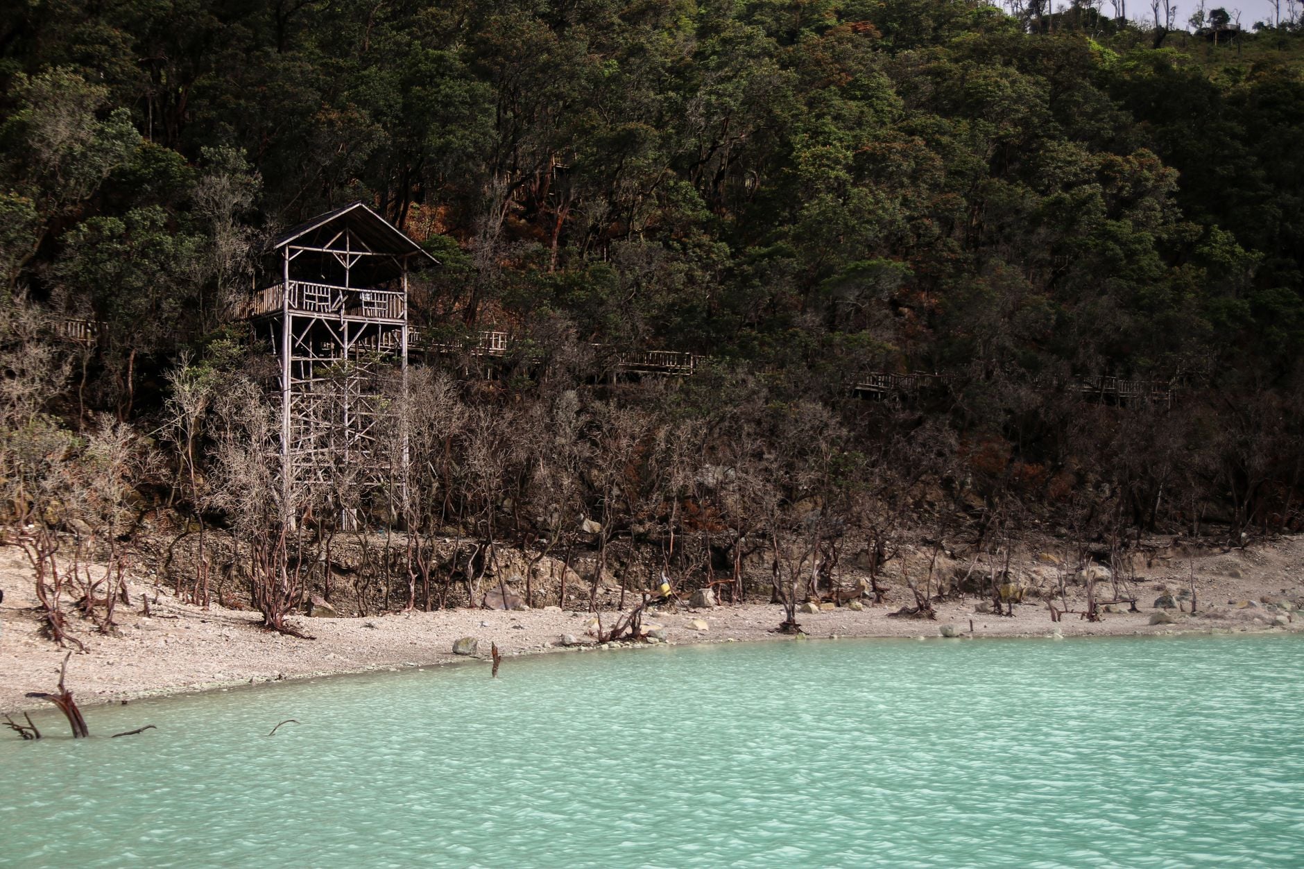 Kawah Putih volcanic crater lake with turquoise water and wooden watchtower at Ciwidey, West Java