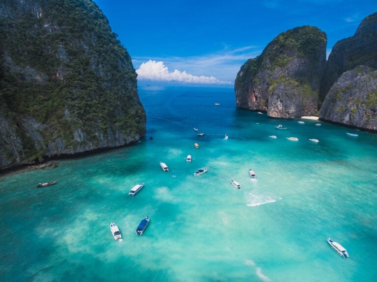 Aerial view of Maya Bay, Koh Phi Phi, Thailand — turquoise water surrounded by limestone cliffs with tour boats anchored below