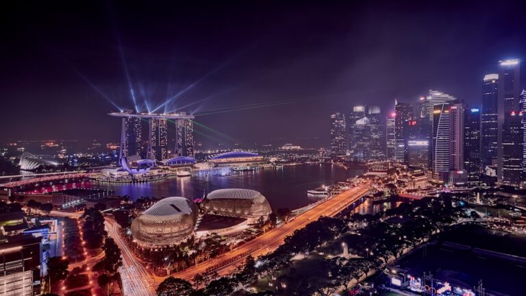 Singapore Marina Bay Sands skyline at night with light beams over the bay
