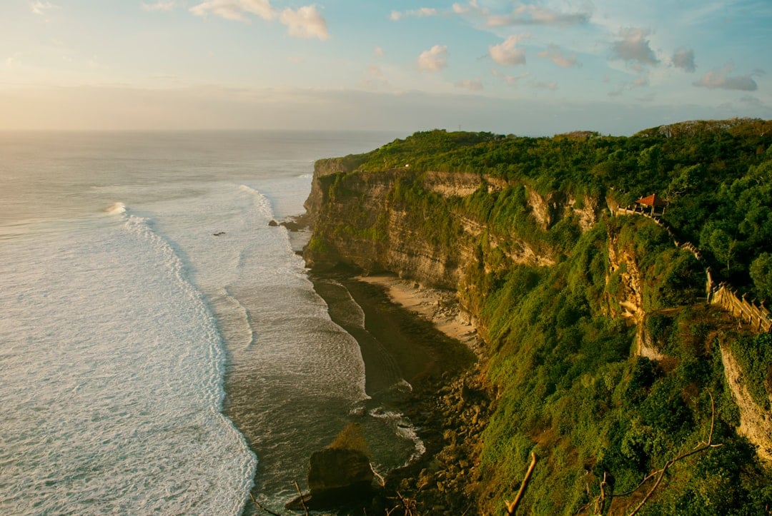 น่าทึ่ง Bali หน้าผาในยามพระอาทิตย์ตกดินที่มองเห็นแนวชายฝั่งมหาสมุทรอินเดีย
