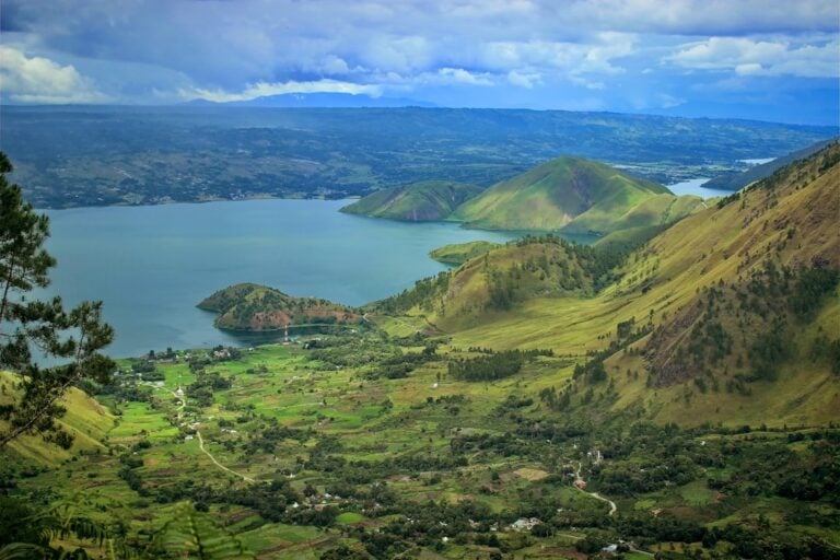Aerial panoramic view of Lake Toba and Samosir Island, North Sumatra, Indonesia, surrounded by green volcanic crater walls