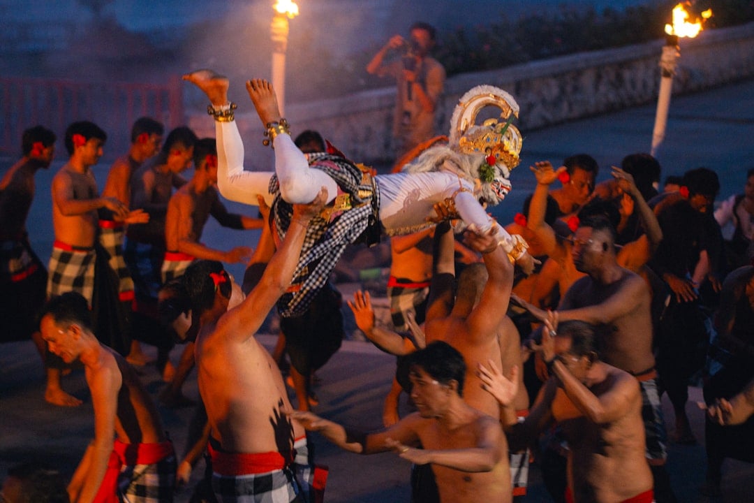 Hanuman performer lifted into the air by dancers during a traditional Kecak fire dance performance in Bali, Indonesia