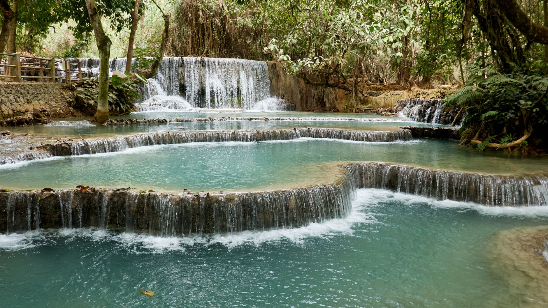 Kuang Si Waterfall multi-tiered turquoise pools surrounded by lush jungle, Luang Prabang, Laos