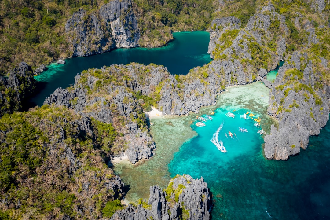 Aerial view of Big Lagoon and Small Lagoon in El Nido, Palawan, with tour boats anchored in turquoise water surrounded by limestone karst formations