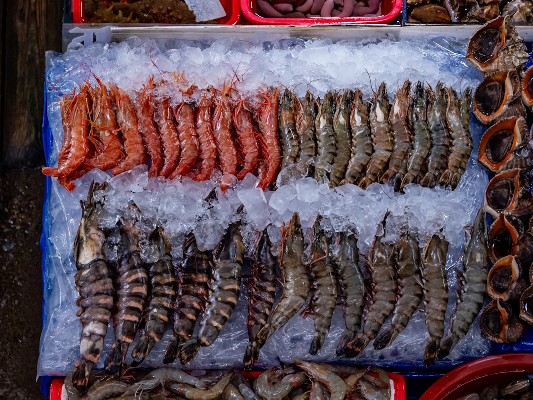 Fresh shrimp and seafood laid out on ice at an open-air Asian seafood market, similar to the Kep Crab Market in Cambodia