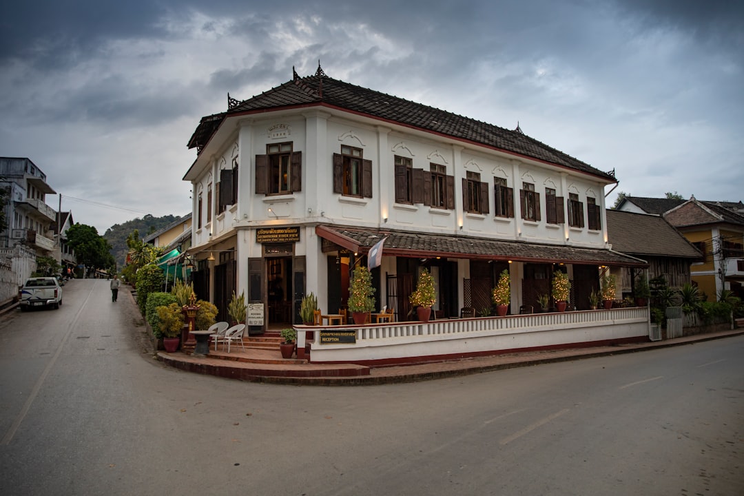French colonial-era building on a street corner in Southeast Asia, with shuttered windows and a wraparound balcony