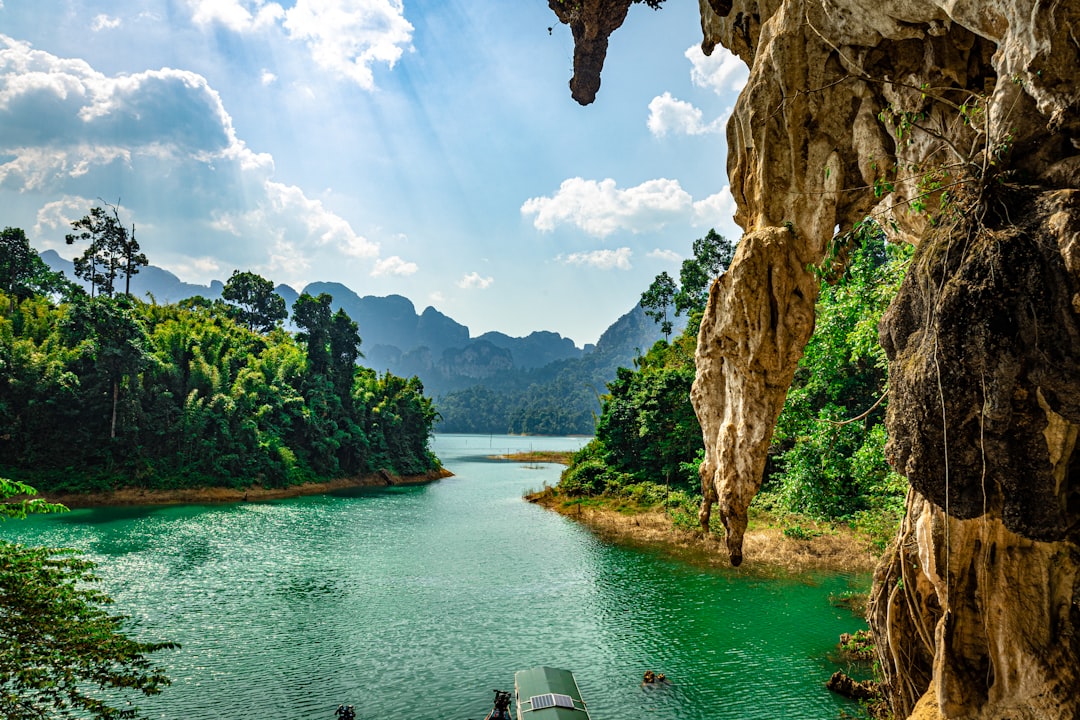 Turquoise water framed by limestone karst cliffs and jungle, similar to the Blue Lagoons near Vang Vieng